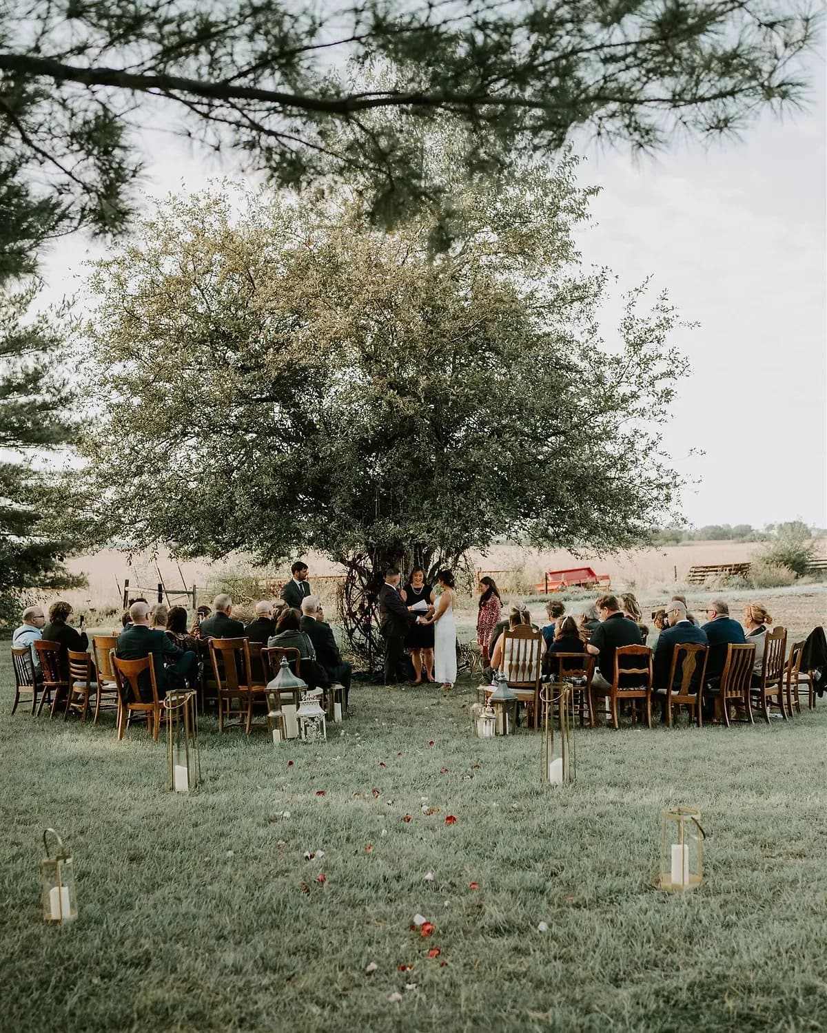 A fully styled wedding reception table with candles, greenery and layered place settings.