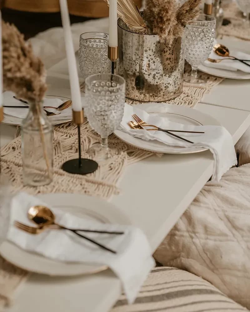 An elegant luxe picnic with a dressed low table, candles and glassware.