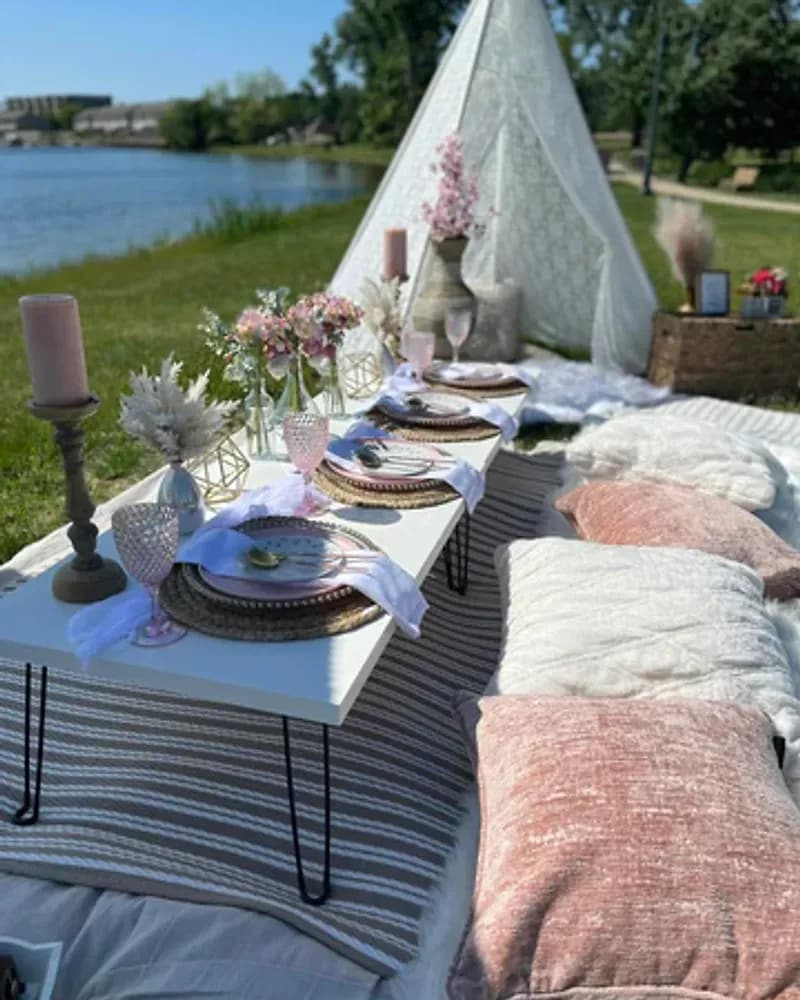 A luxe picnic with a rose themed table setting under a clear bubble tent.